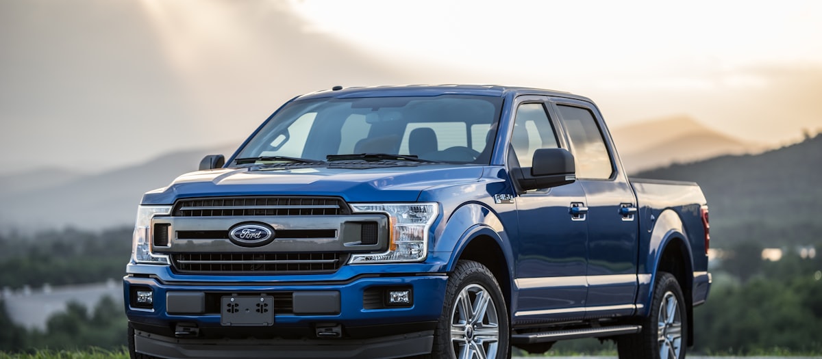 Pick-up Ford bleu devant un paysage de montagne